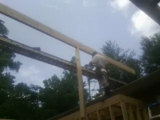 Carpenter setting a ridge beam over a new addition frame — Ice Dam Removal by Roofing Brothers in Tremonton