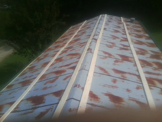 Rusted metal roof panels with new wood purlins before replacement — Storm Damage Roof Repair in Tremonton by Roofing Brothers