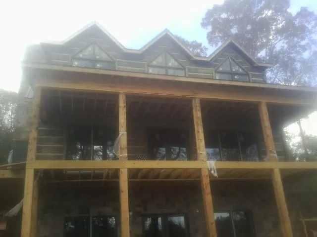 Dormers and porch framing on a large log home under construction — Roof Coating work by our crew in Tremonton
