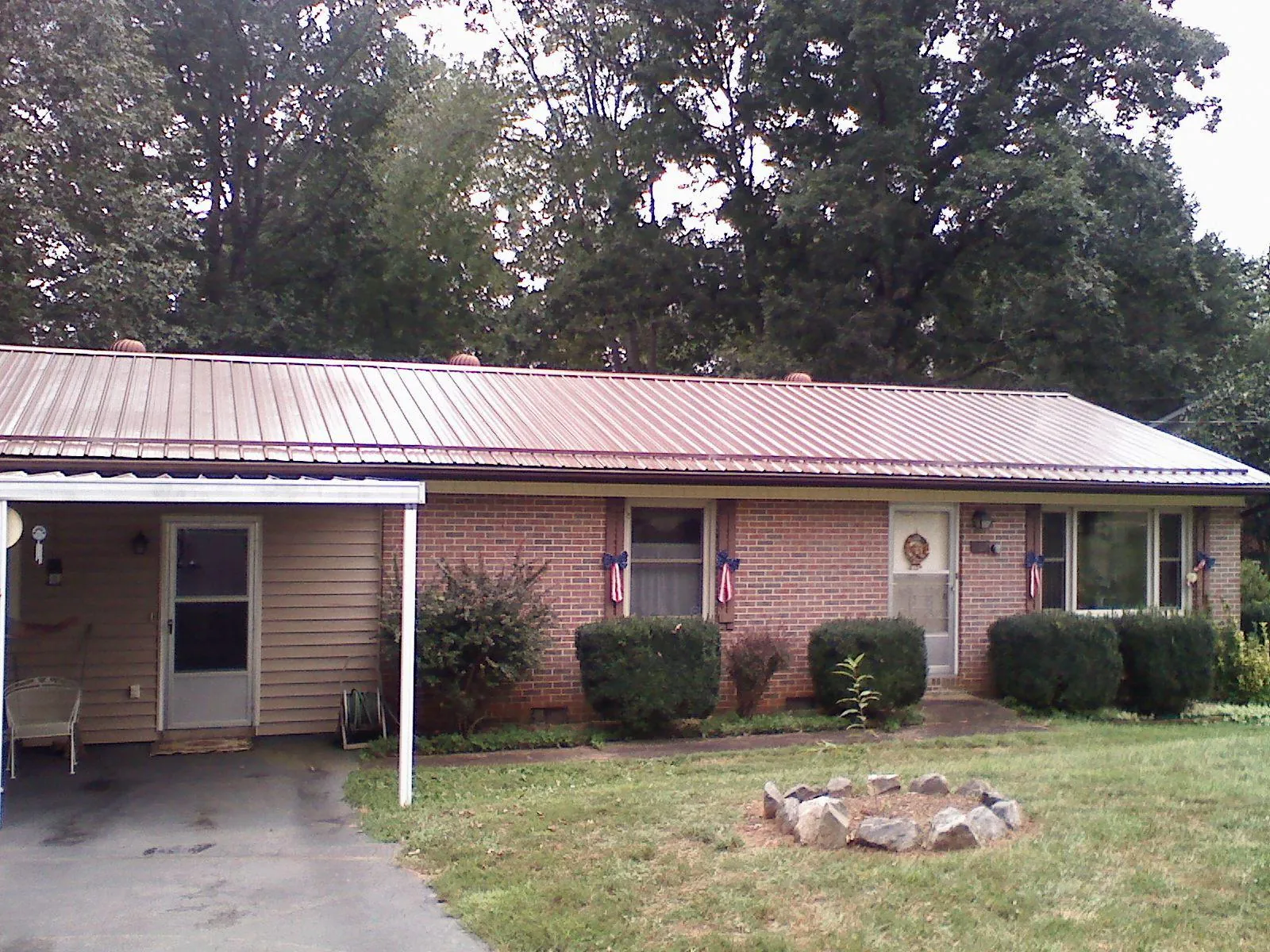 Bronze metal roof and carport on a brick ranch home — Roof Repair work by our crew in Tremonton